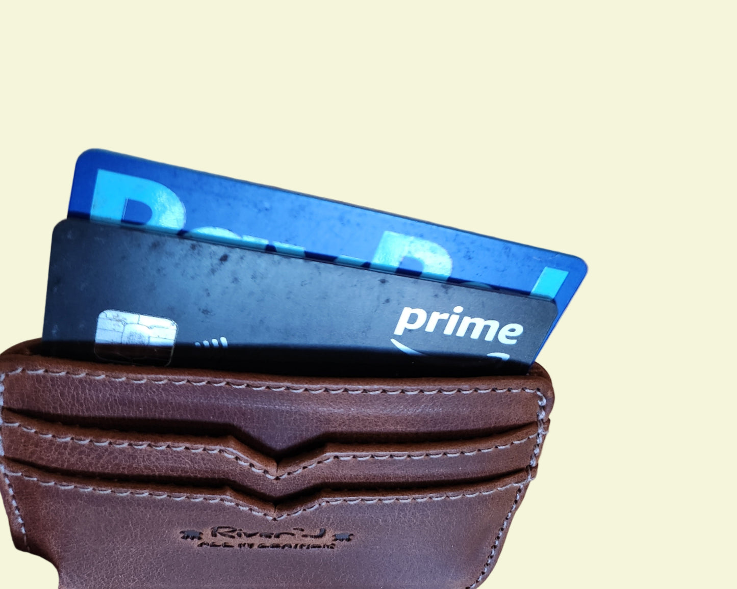 Brown wallet with two cards on a wooden surface