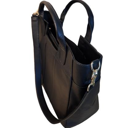 Black handbag with a silver clasp on a wooden floor