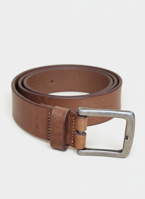 Brown leather belt with a silver buckle on a wooden surface