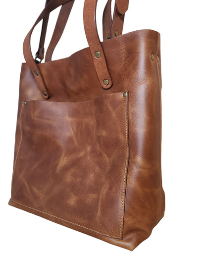 Brown leather bag on a wooden surface