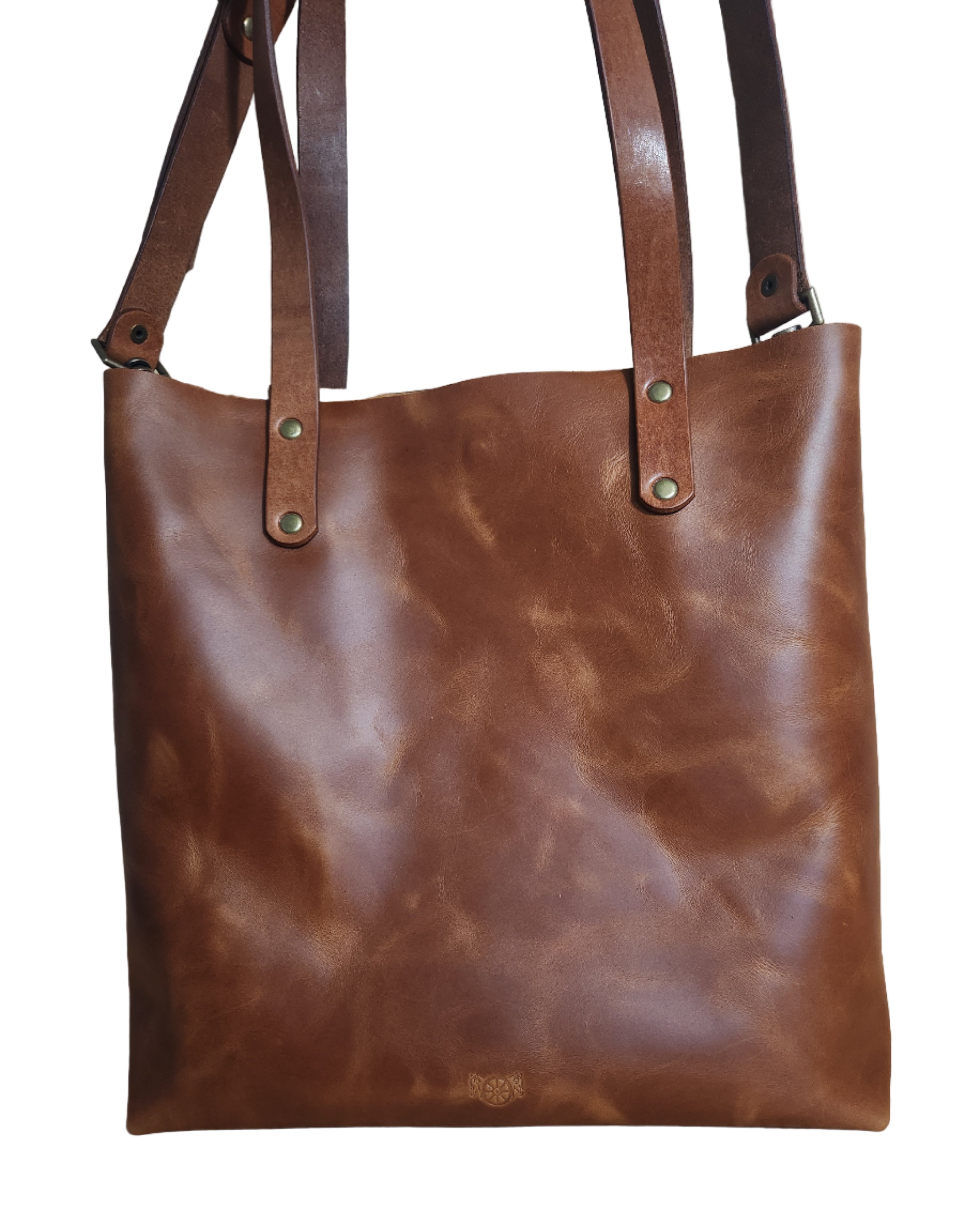 Brown leather bag with strap on a wooden floor