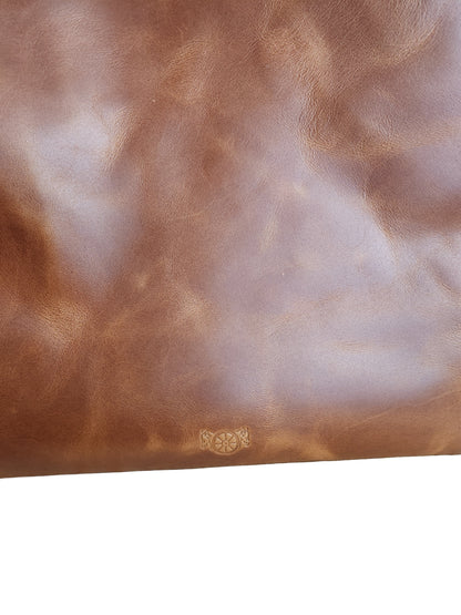 Brown leather surface with a subtle pattern on a wooden background