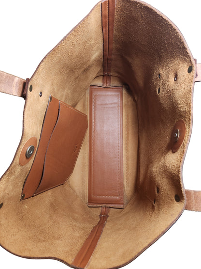 Brown leather bag with visible stitching on a wooden surface