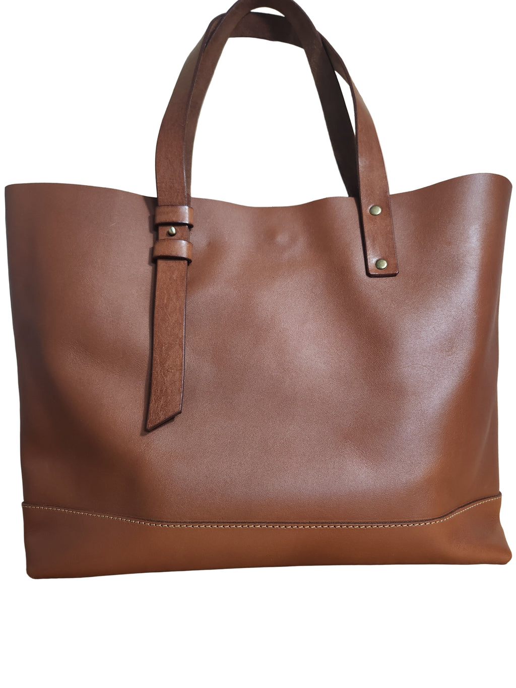 Brown leather tote bag on a wooden surface