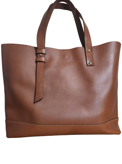Brown leather tote bag on a wooden surface