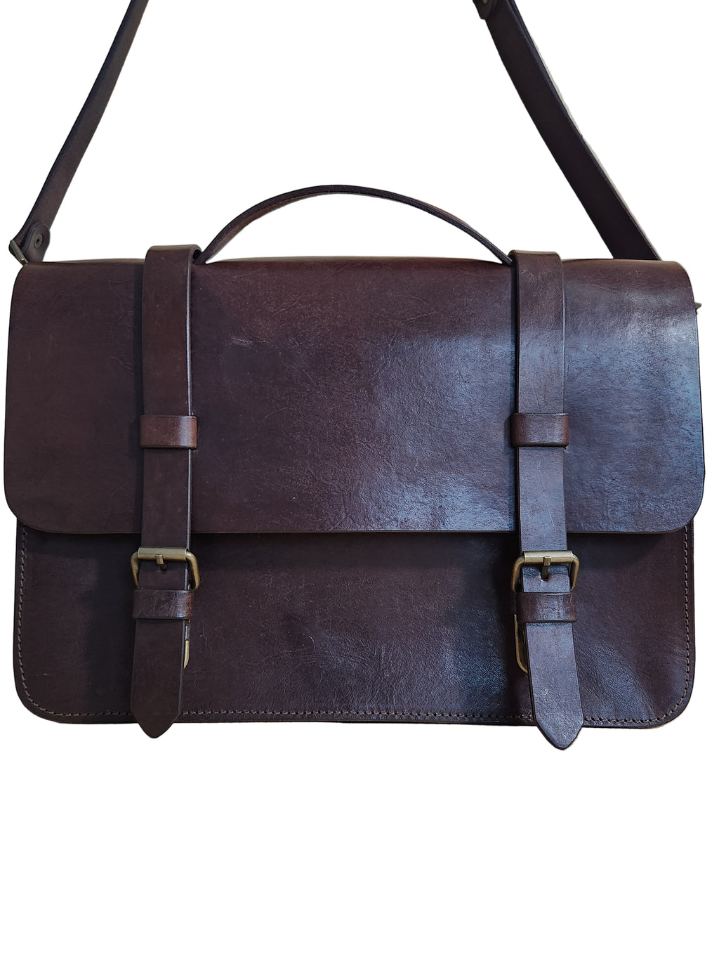 Brown leather bag with straps on a wooden surface