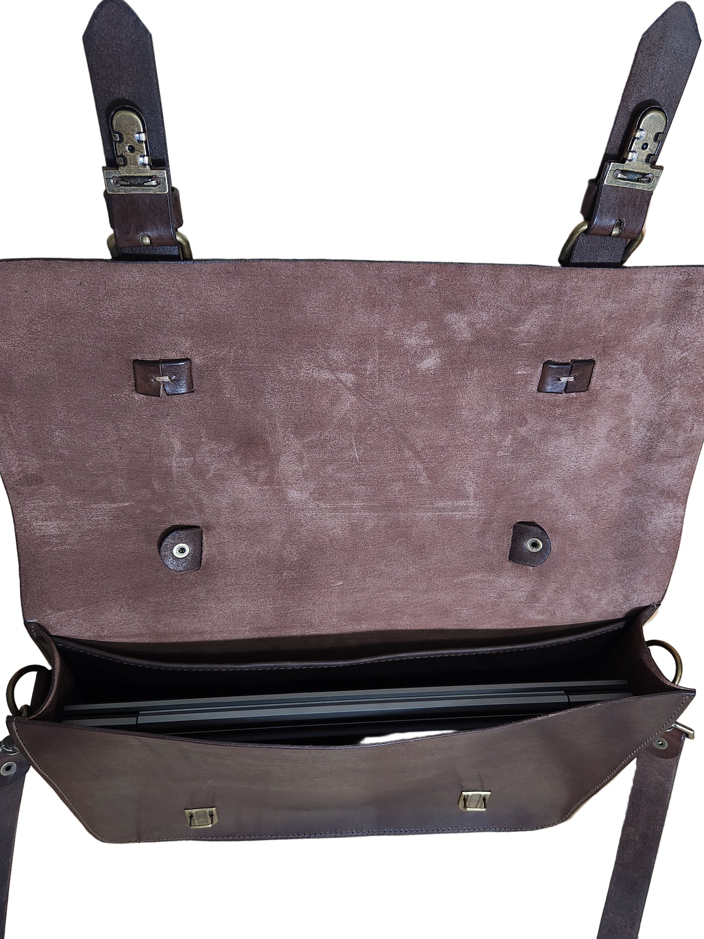 Brown leather briefcase with multiple buckles on a wooden surface