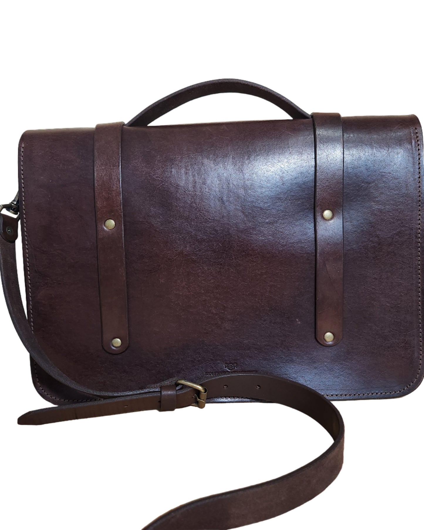 Brown leather bag with strap on a wooden surface