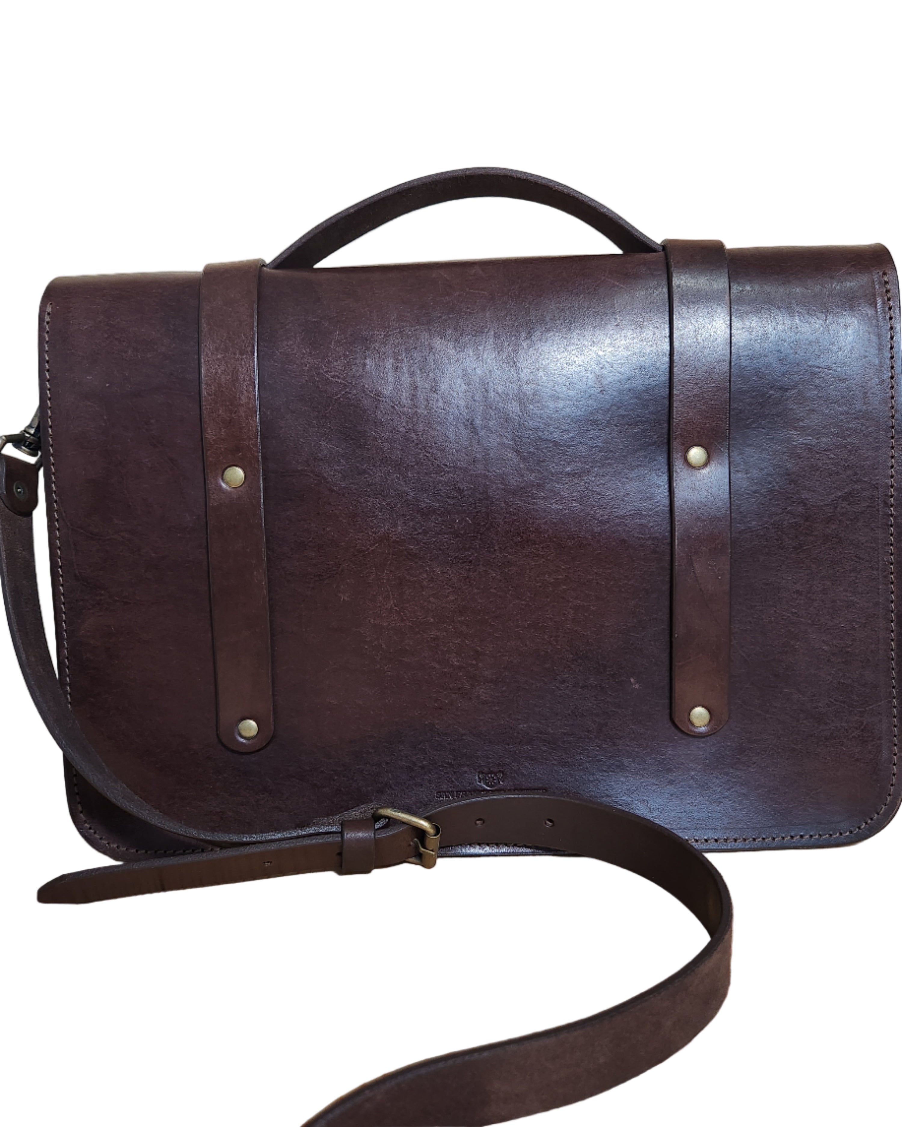 Brown leather bag with strap on a wooden surface
