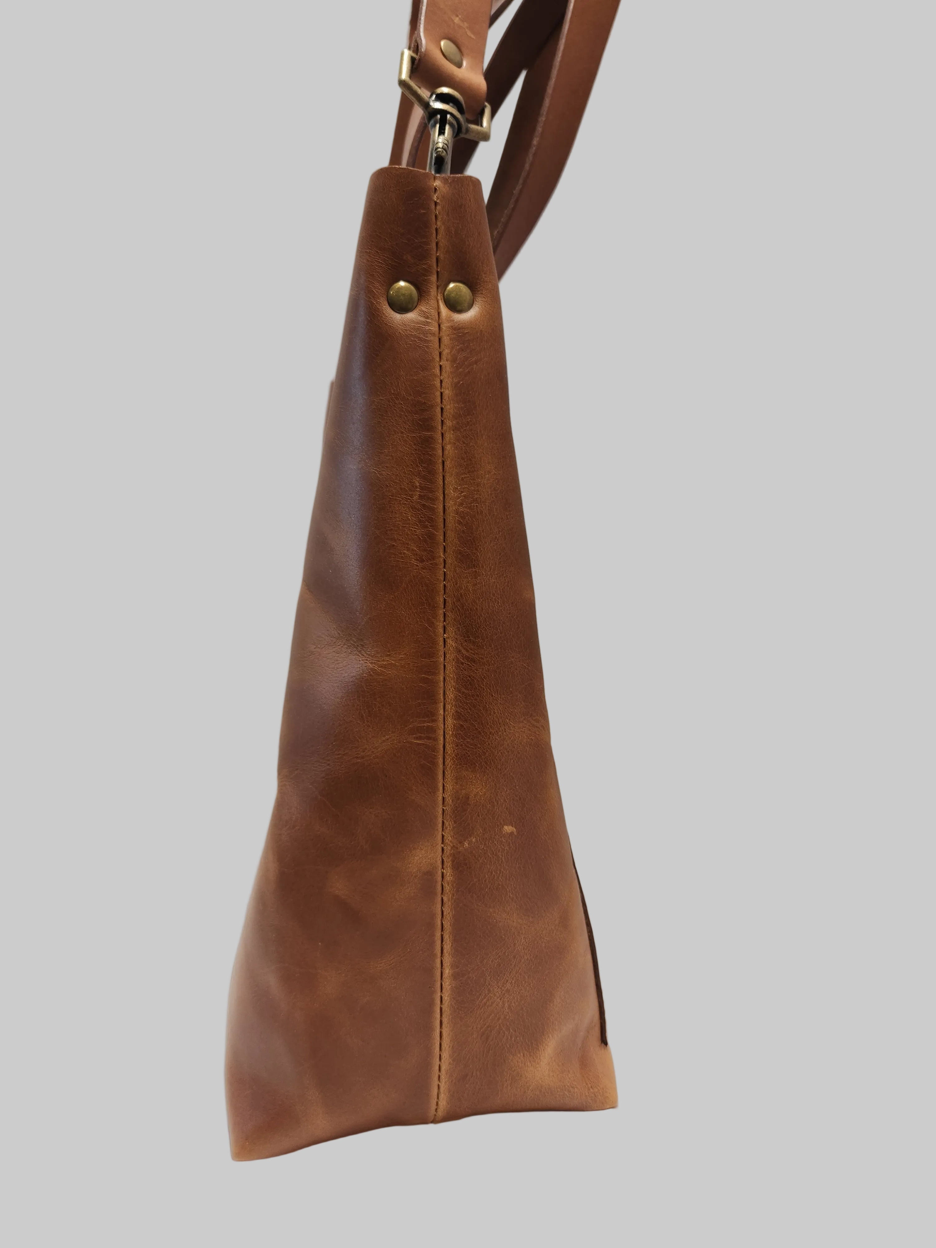 Brown leather handbag on a light gray background