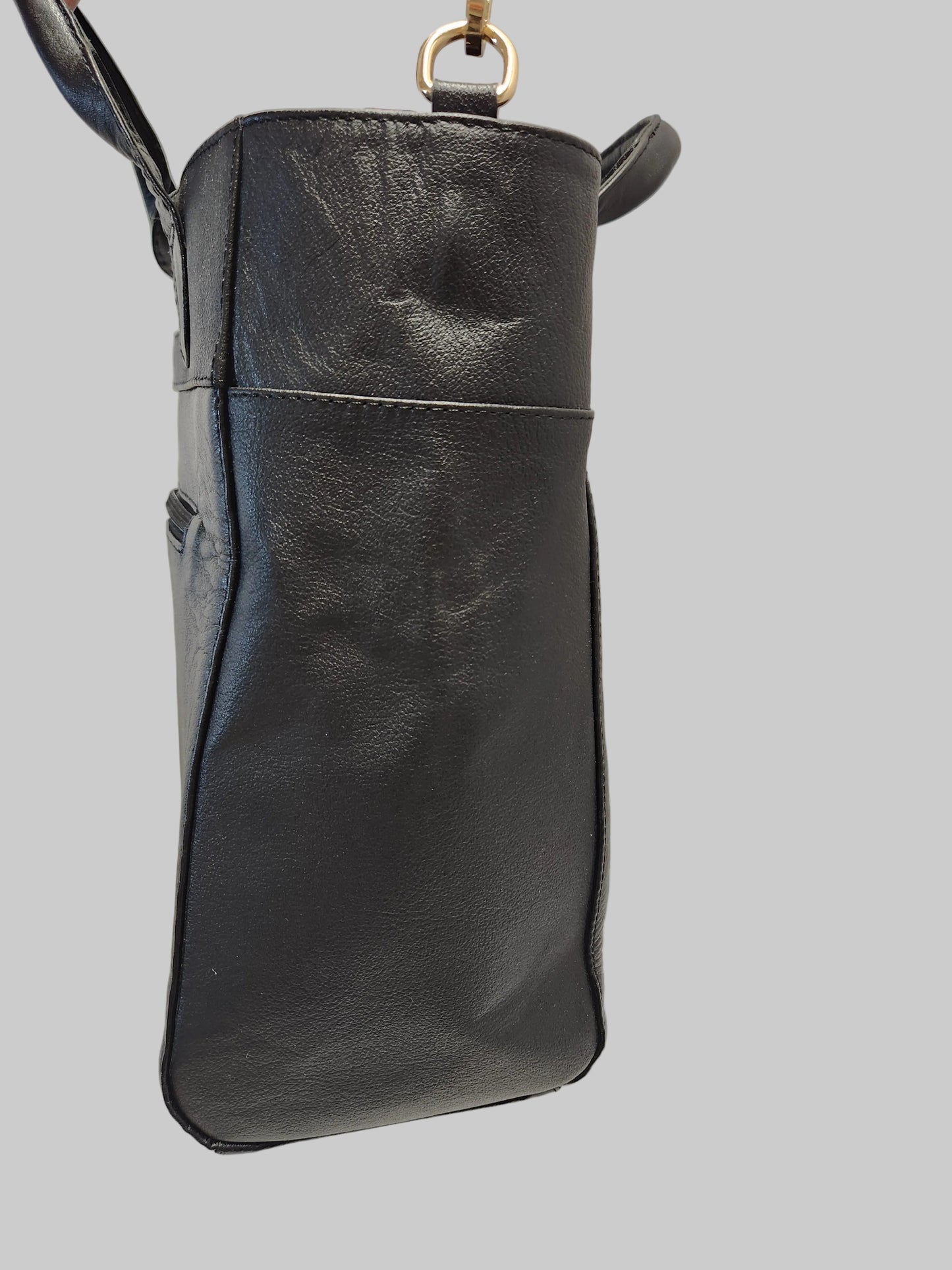 Black leather handbag on a light gray background