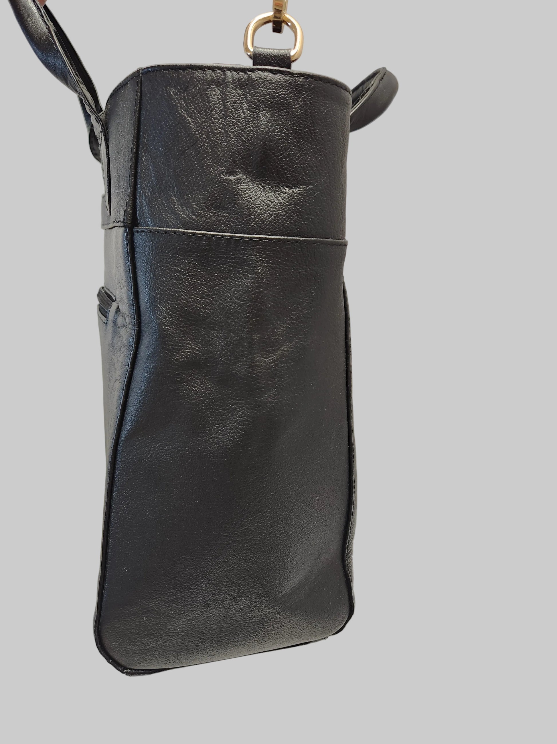 Black leather handbag on a light gray background