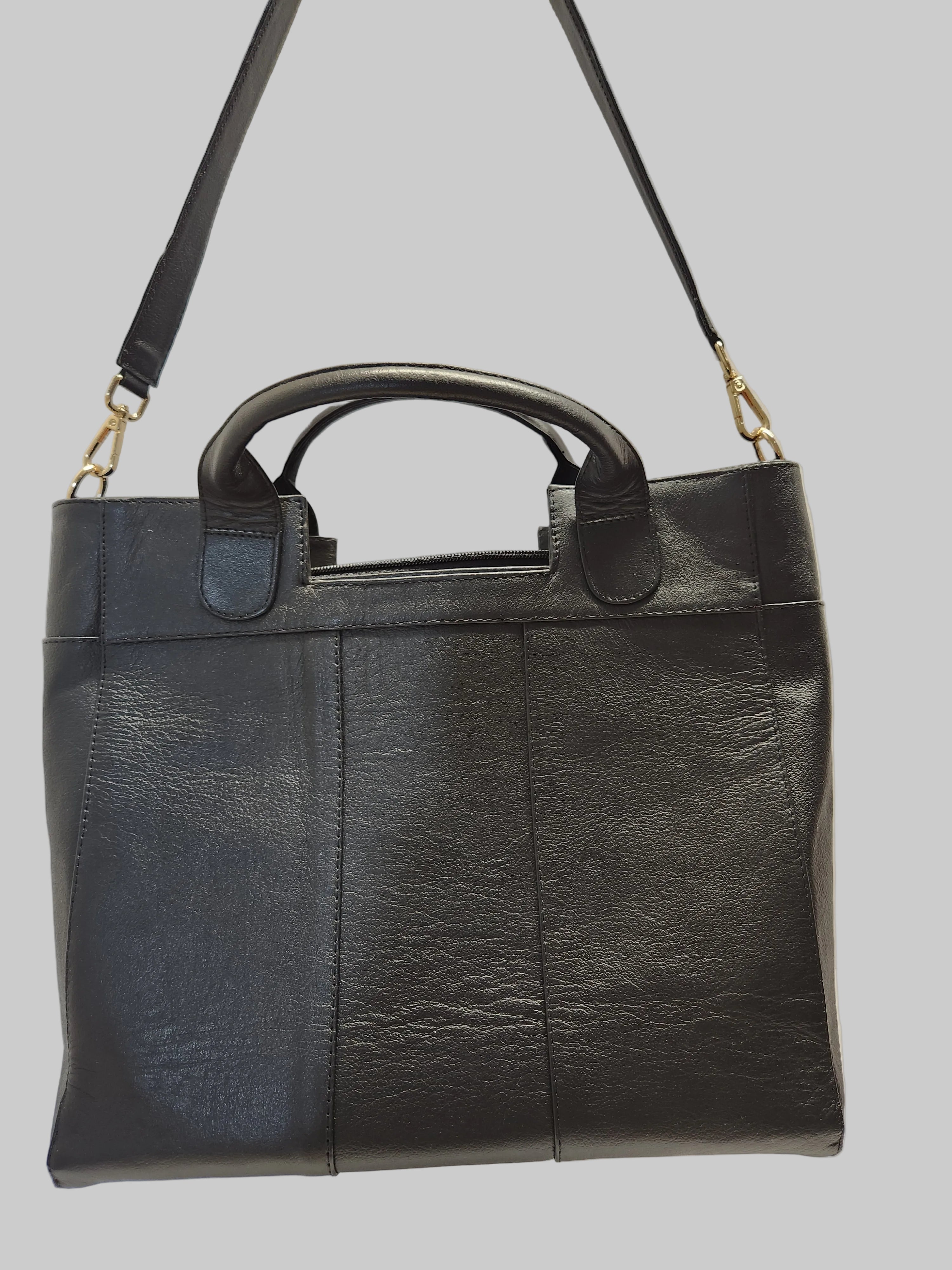 Black leather bag with a shoulder strap on a light gray background