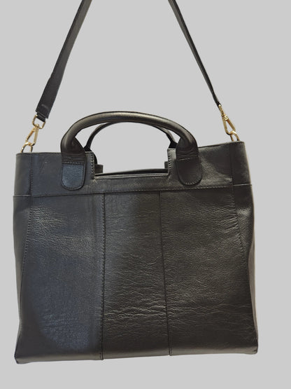 Black leather bag with a shoulder strap on a light gray background