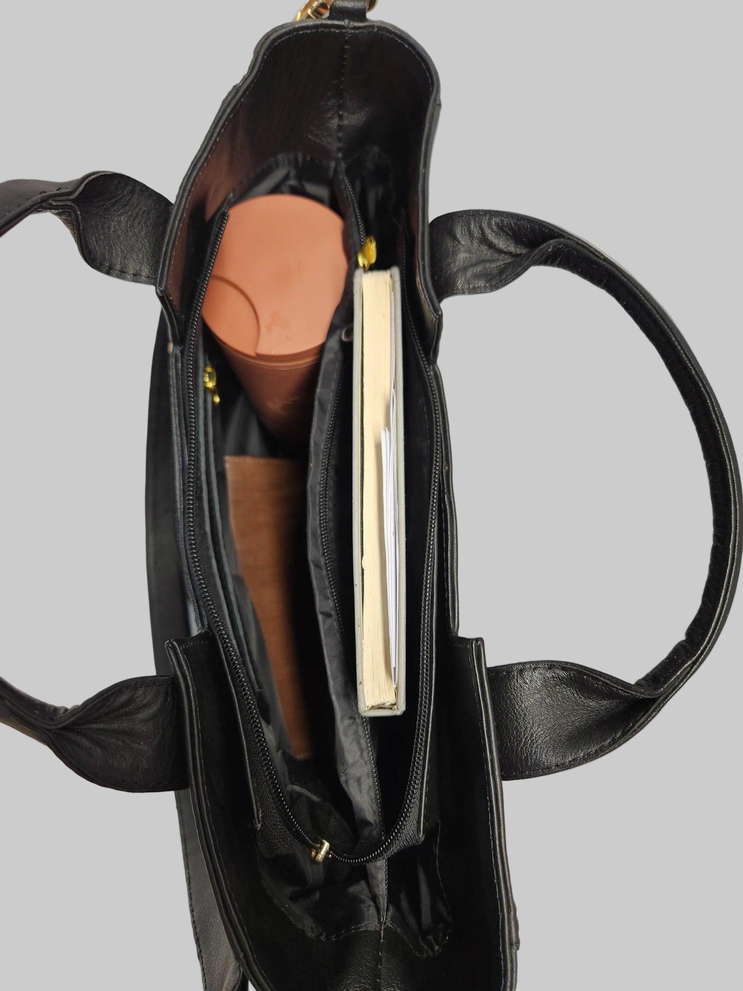 Black handbag with a gold clasp on a white background