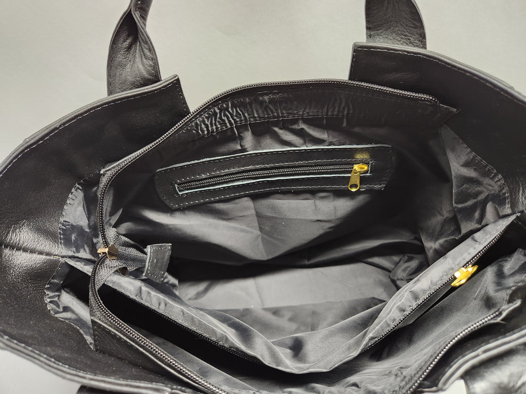 Black leather bag with open interior showing a checkered pattern.