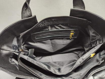 Black leather bag with open interior showing a checkered pattern.