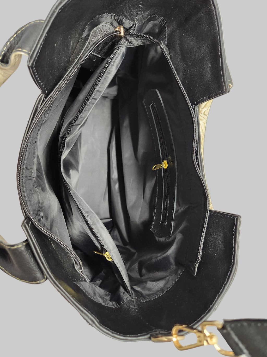 Black handbag with gold accents on a light gray background