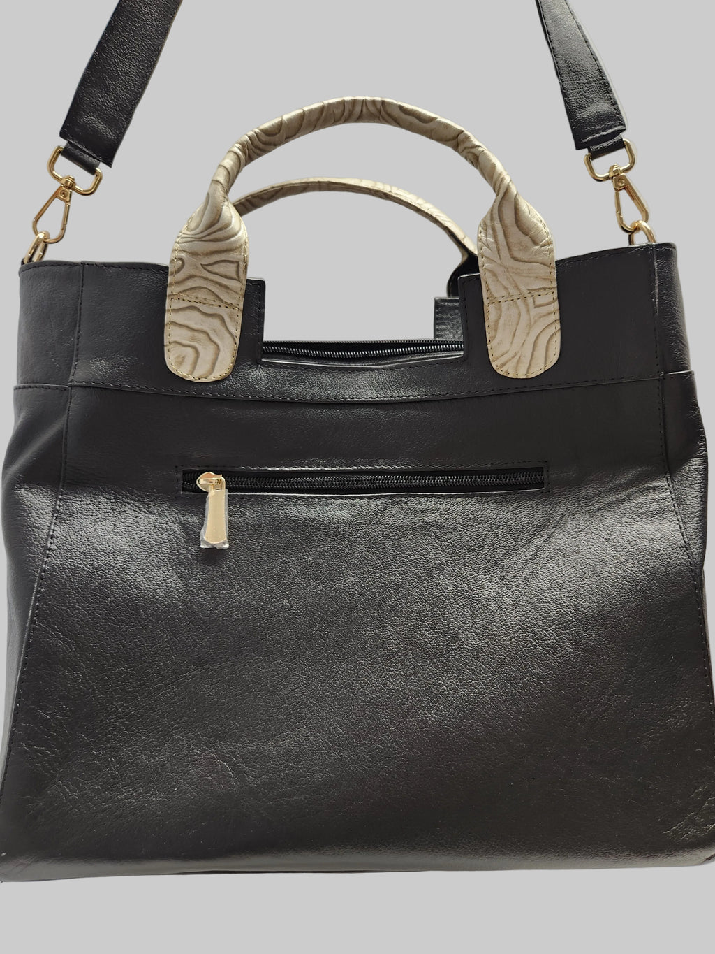 Black leather handbag with beige handles on a light gray background