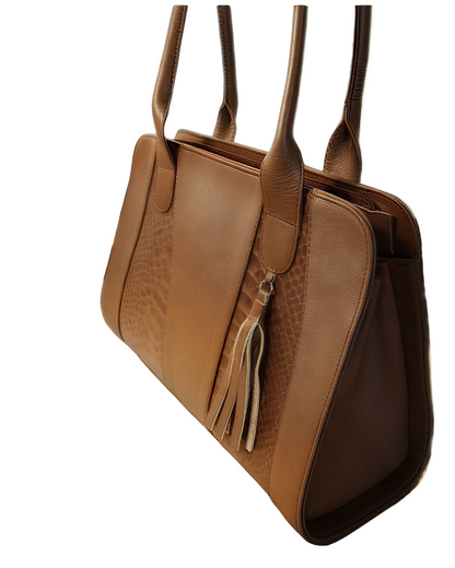 Brown leather handbag with tassel on a wooden surface with pumpkins and leaves