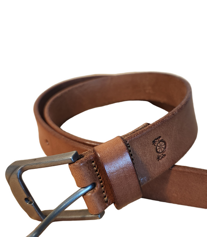 Brown leather belt with a metal buckle on a wooden surface