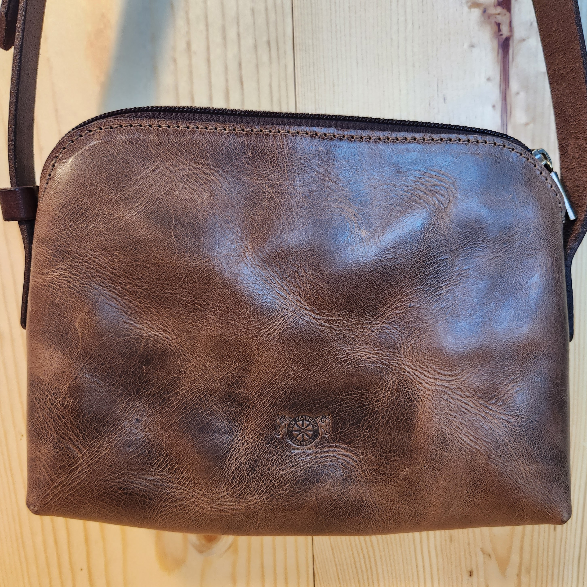 Brown leather pouch on a wooden surface