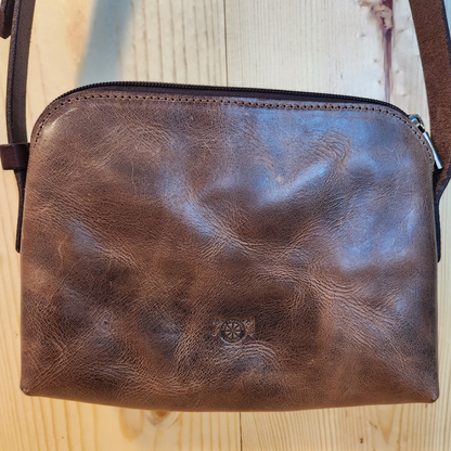 Brown leather pouch on a wooden surface