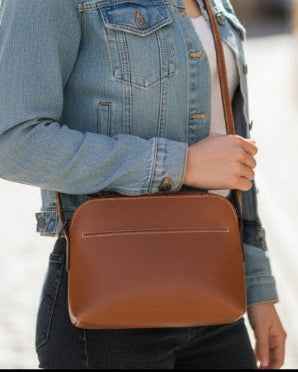 Woman holding a brown leather bag on a street