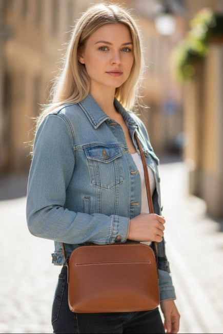 Woman holding a brown leather bag on a street