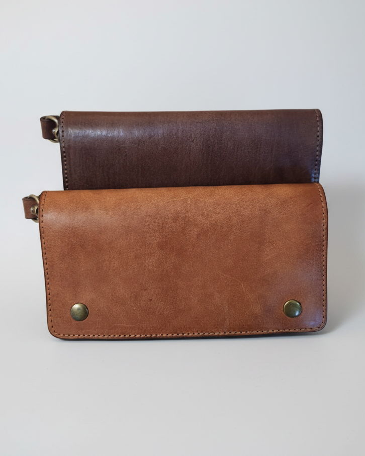 Two leather wallets, one brown and one black, on a marble surface
