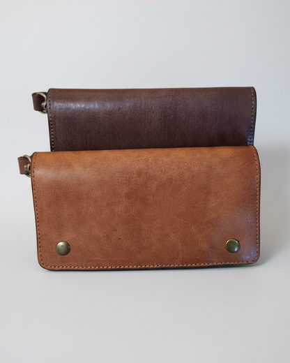 Two leather wallets, one brown and one black, on a marble surface
