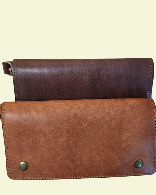 Two leather wallets, one brown and one black, on a marble surface