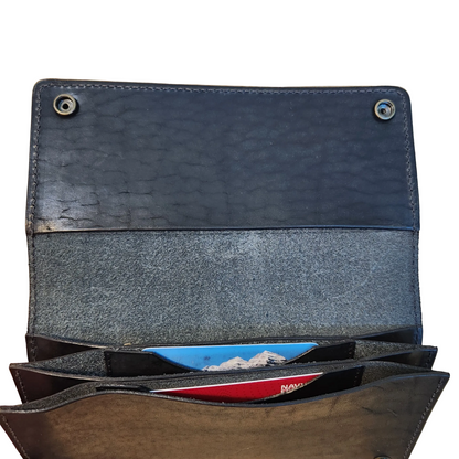 Open leather wallet with card slots on a wooden surface