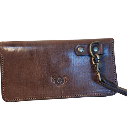 Brown leather wallet with a strap on a wooden surface