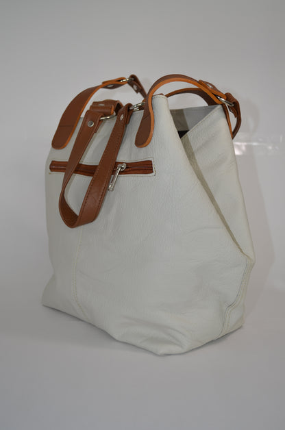 White tote bag with brown leather straps on a white background