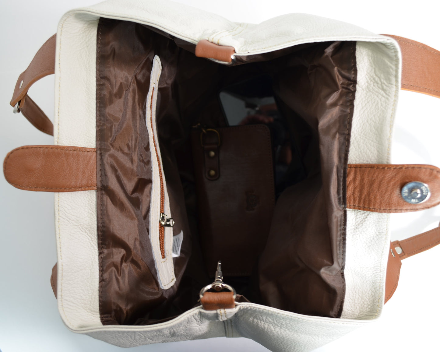 White bag with brown interior and straps on a white background