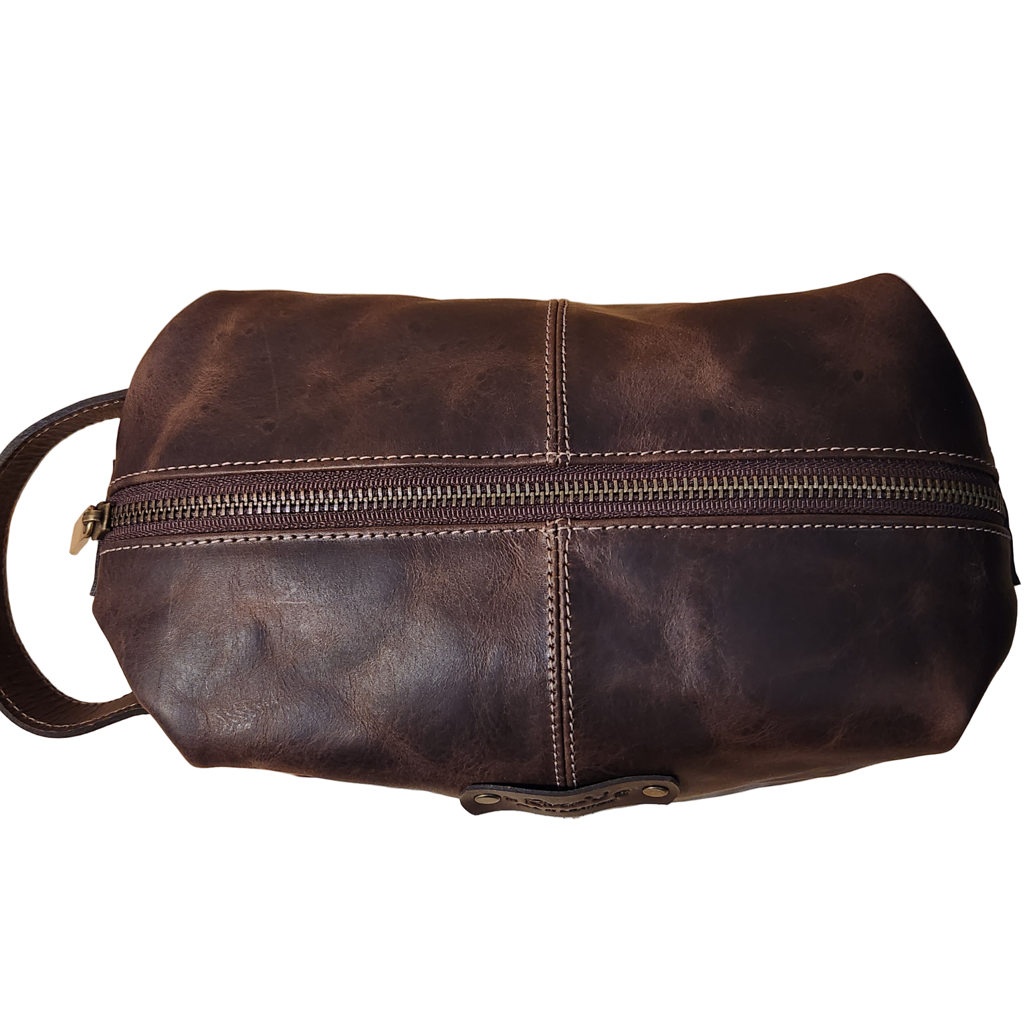 Brown leather dopp kit with a zipper on a beige background