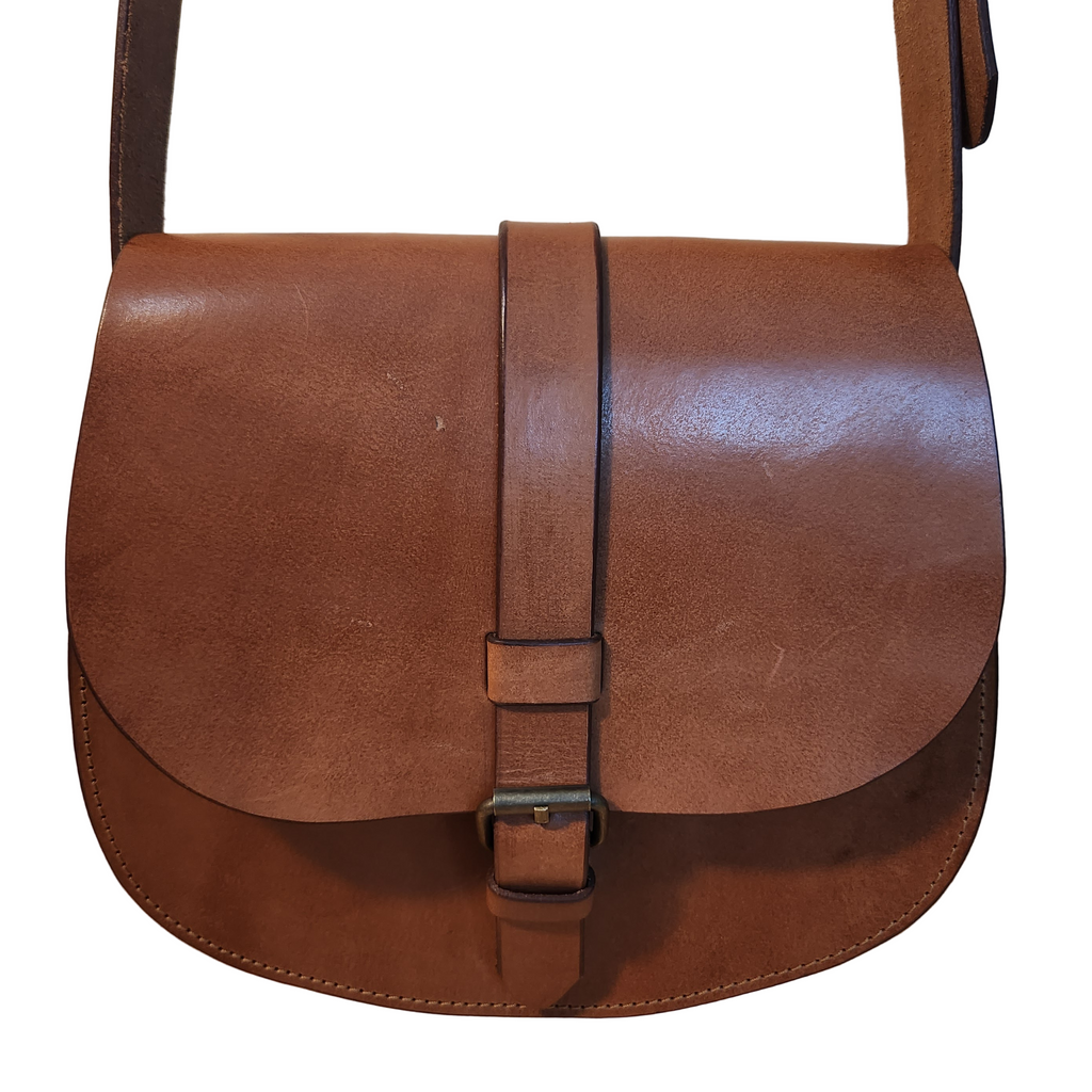 Brown leather satchel bag on a wooden surface