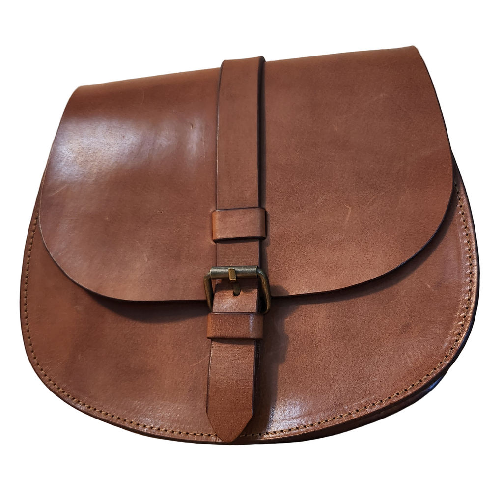 Brown leather saddle bag on a wooden surface
