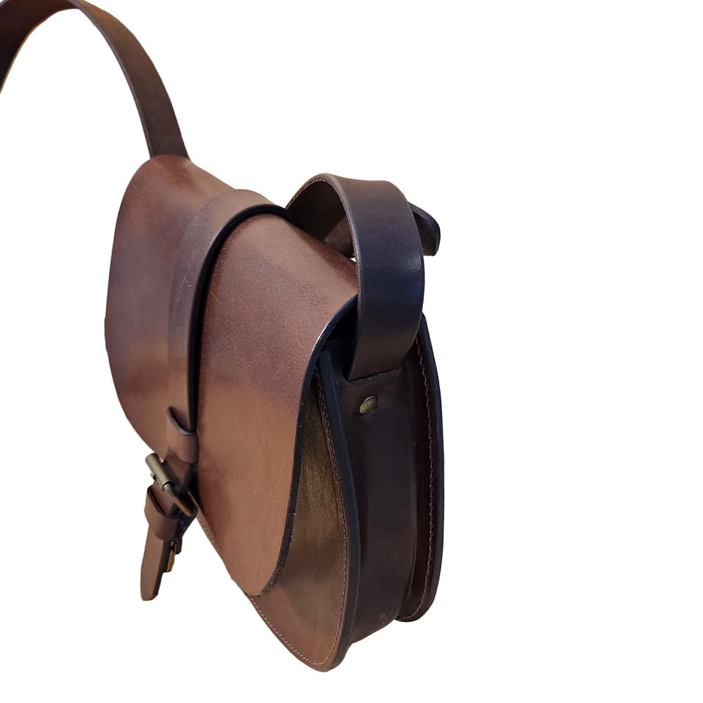 Brown leather bag on a wooden surface