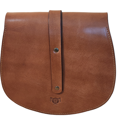 Brown leather bag with a strap on a wooden surface