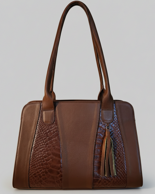 Brown leather handbag with textured pattern on a wooden surface
