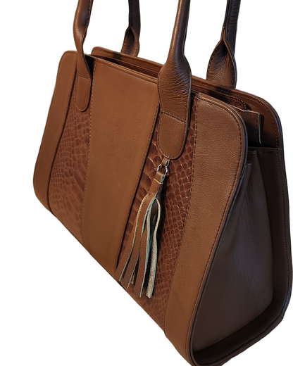 Brown leather handbag with a tassel on a beige background