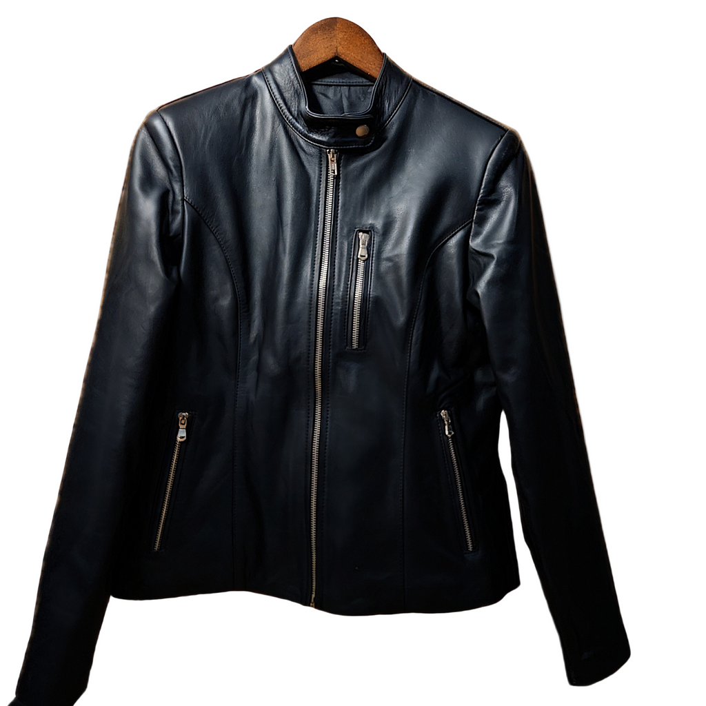 Black leather jacket on a wooden hanger against a rustic wooden background with autumn leaves.