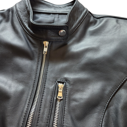 Close-up of a black leather jacket with gold zipper details on a white background