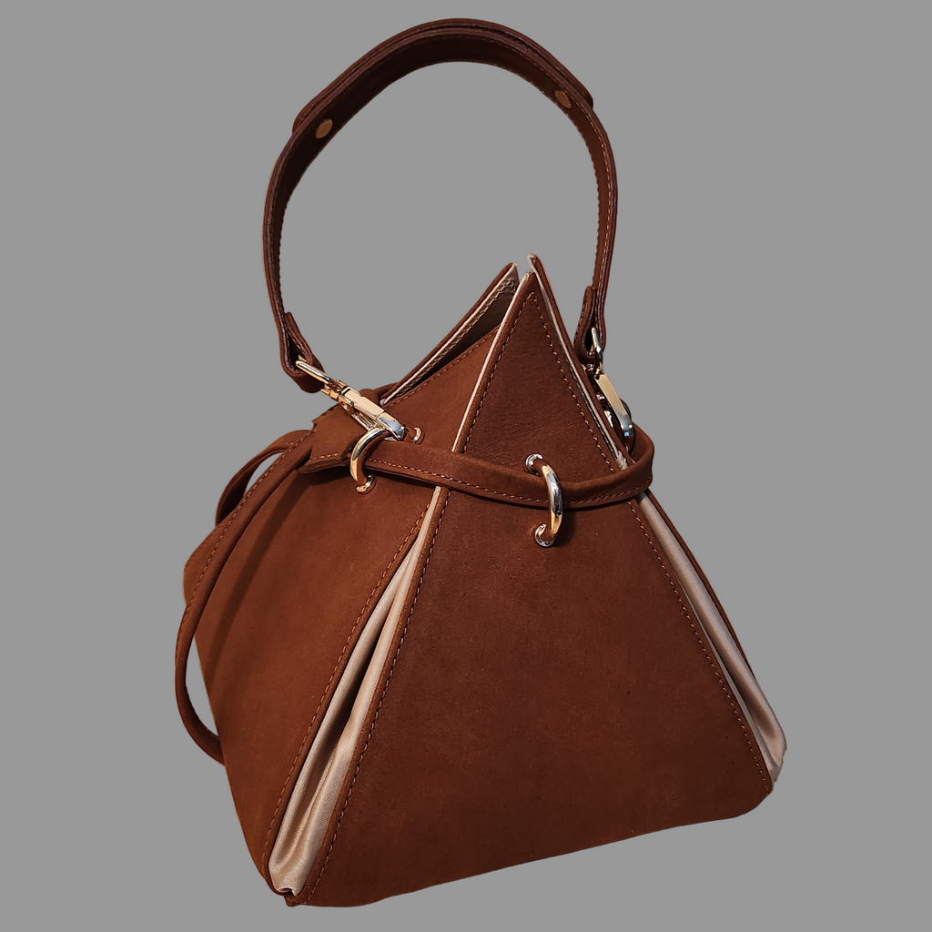 Brown handbag with beige interior on a wooden surface