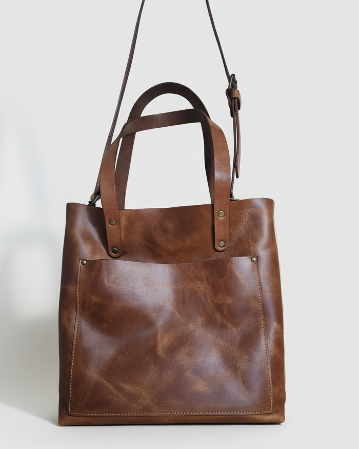 Brown leather bag on a wooden surface