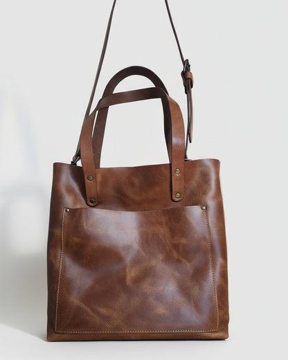 Brown leather bag on a wooden surface