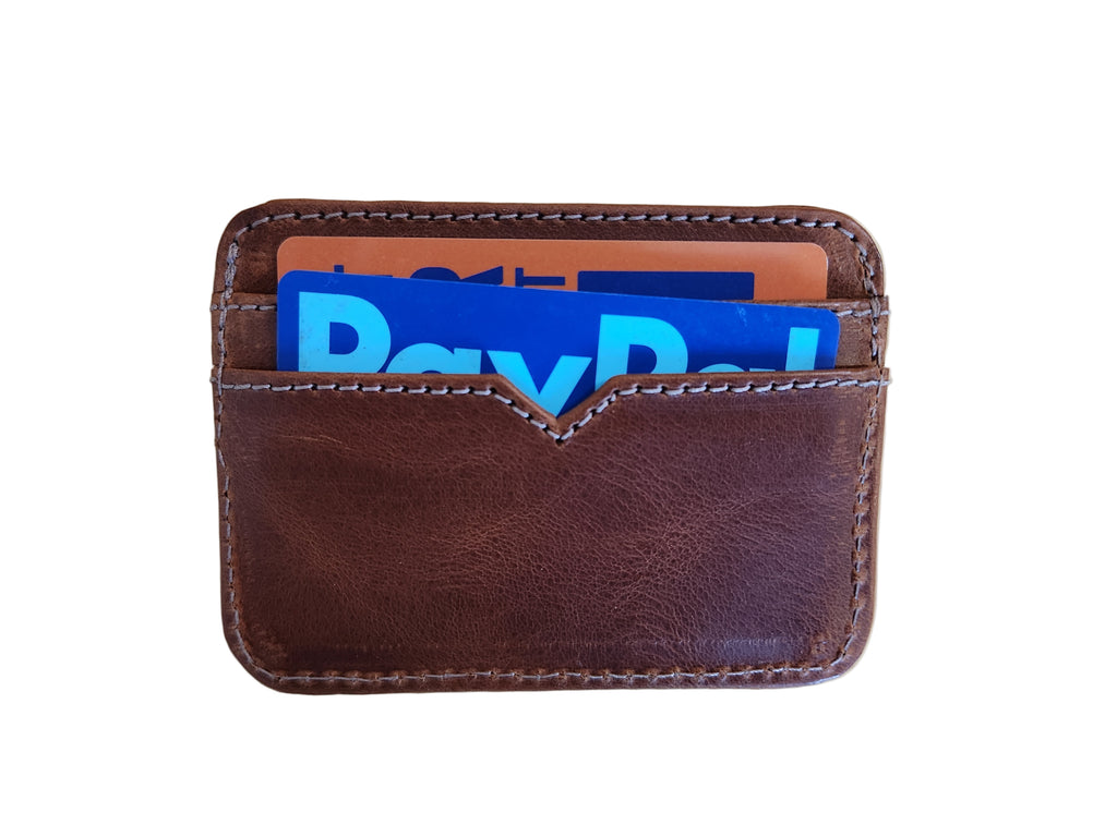 Brown leather wallet with colorful cards on a wooden surface