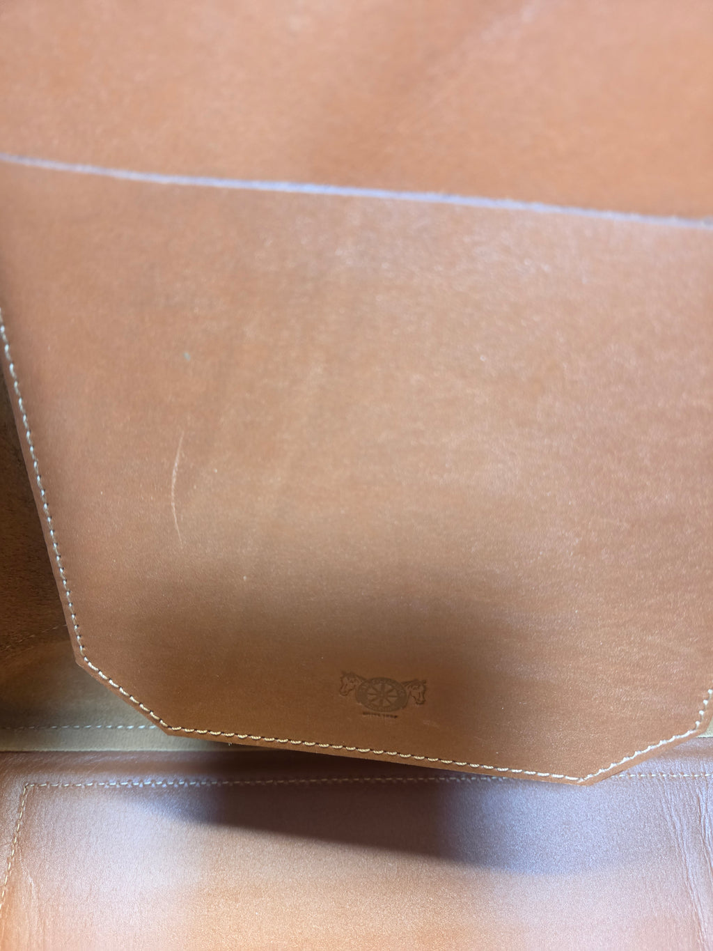 Close-up of a beige leather product with stitching details